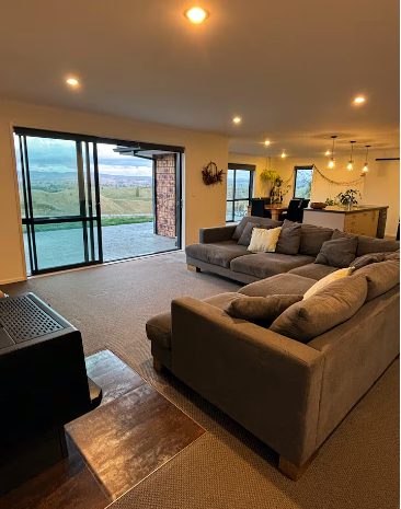 Open-plan living area with large windows framing the rural view — The Home on the Hill