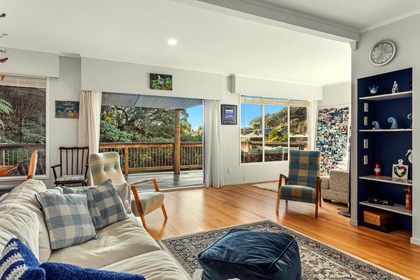 Coastal living room opening to the deck and garden — 2 Wagner Place, Ohiwa